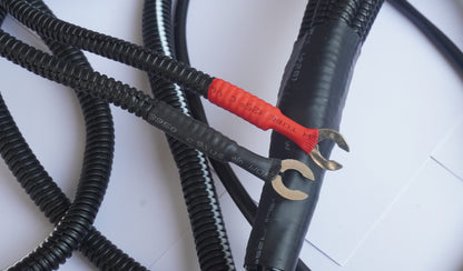 Black cables with red and silver connectors on a white background
