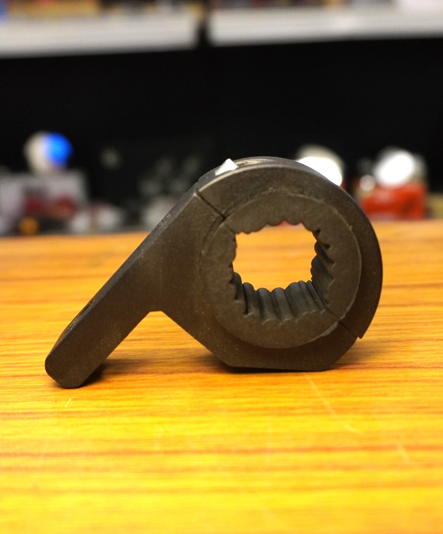 Black metal gear on a wooden surface with a blurred background