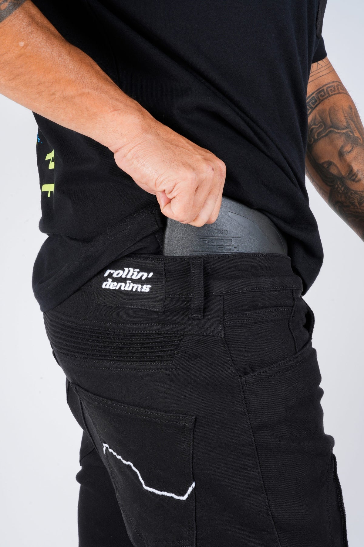Grey hip protector partially inserted into the internal hip pocket of Genesis 2.0 black riding jeans | MotoARZT