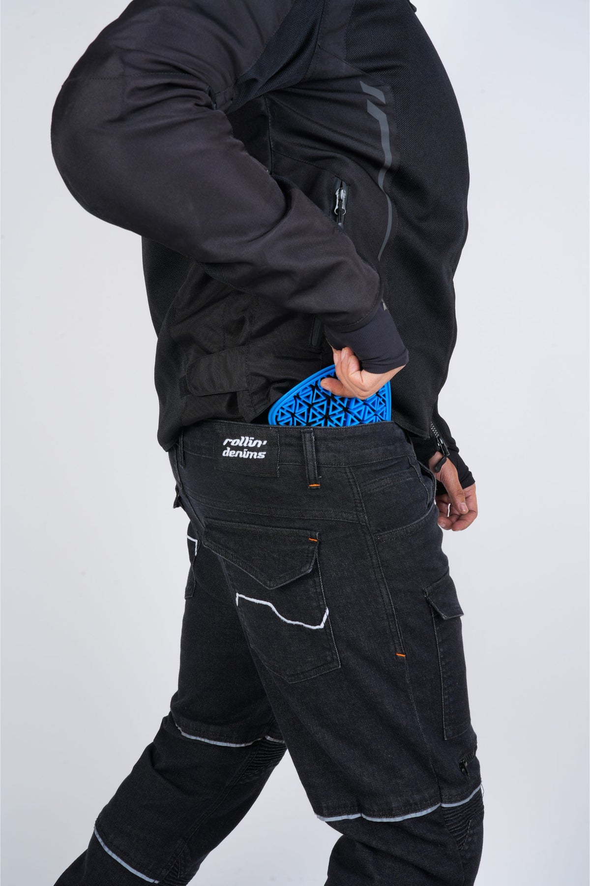 Blue lattice-style hip protector partially inserted at the waistband of black Rollin’Denims riding jeans | MotoARZT