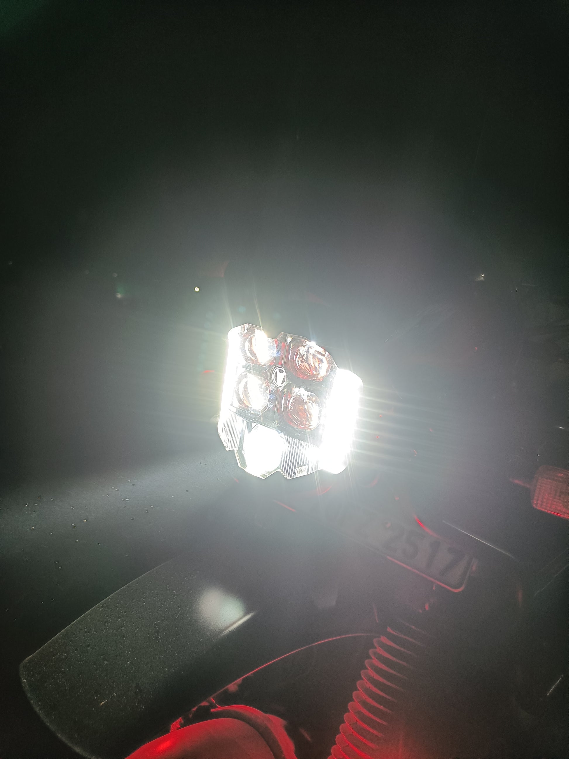 Himalayan 411  Close-up of a motorcycle  headlight with bright light shining through the dark.