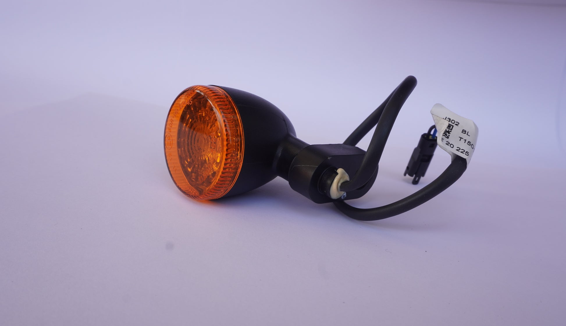 Orange motorcycle turn signal light on a white background