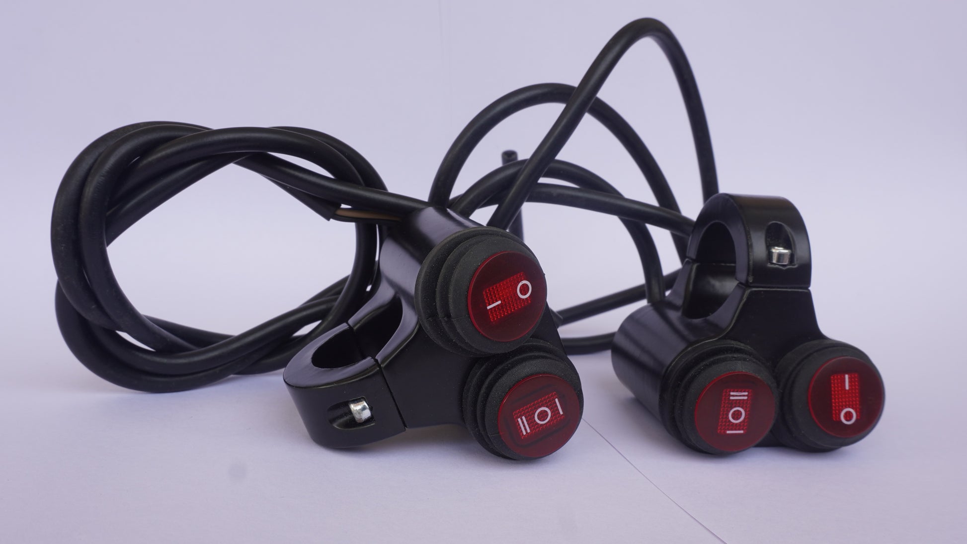 Three motorcycle switches with red lights on a white background