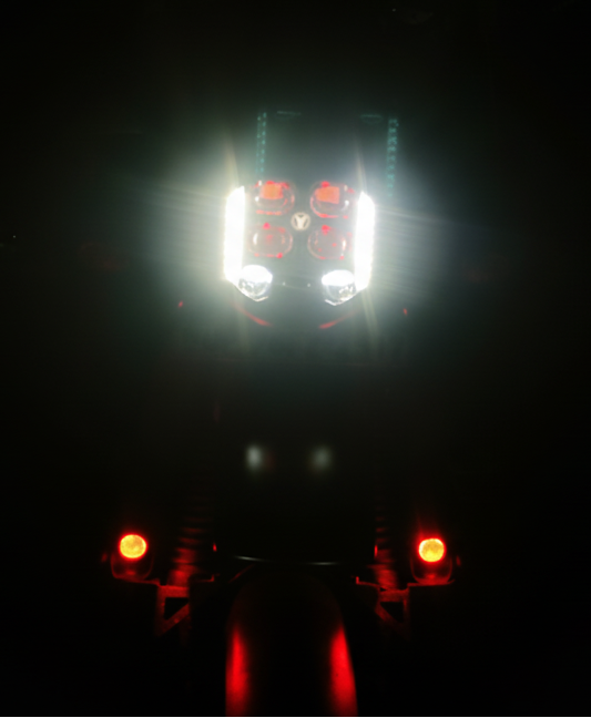 Front view of a vehicle with headlights on in complete darkness